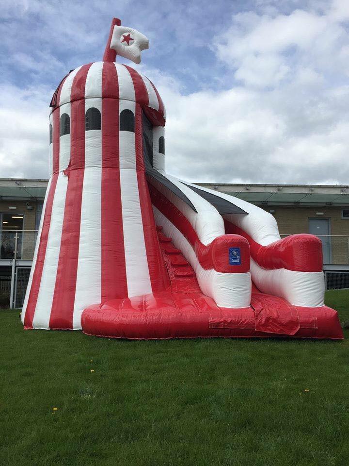 A beautiful red and white inflatable helter skelter set up and ready to use!